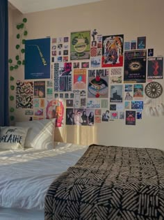 a bed sitting in a bedroom next to a wall with pictures on it