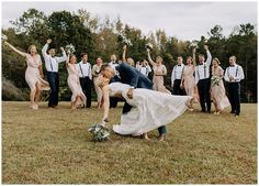 a bride and groom are kissing in front of their wedding party on the grass outside