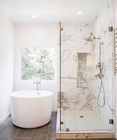 a large white bath tub sitting next to a window