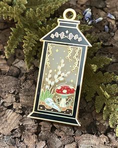 Item Details Size - 2.25" Each Plating - Gold Fill - Hard Enamel Clutch - 2, Green Rubber I wanted this year's lantern to be a view into an enchanted forest.  Filled with mushrooms, greenery, and all sorts of oddities.  A small skull of a bird can be seen nestled amongst the vegetation.  Plated in gold, and filled with a warm translucent enamel, the yellow twinkling stars teleport the viewer into a world of magic. Part of my 2022 Halloween Nature Inspired Collection. Thanks for checking out my p Mushroom Lantern, Fae Magic, Halloween Nature, Garden Witch, My 2022, Halloween Fairy, Small Skull, Magic Garden