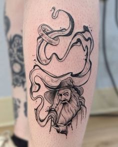 a tattoo on the leg of a man with an octopus and snake around his head