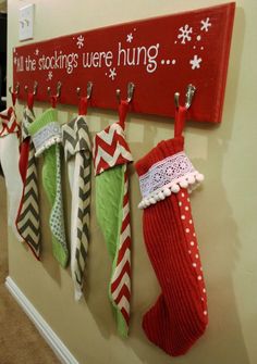 stockings are hung up on the wall in front of a sign that says fill the stockings were hung