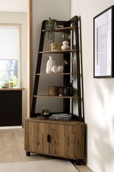 a wooden shelf with vases and other items on it in a living room area