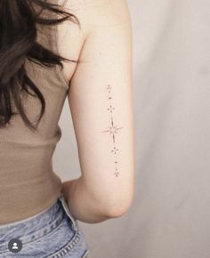 a woman with a small star tattoo on her left arm, behind her back shoulder