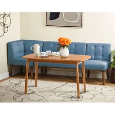 a blue couch sitting next to a wooden table on top of a carpeted floor