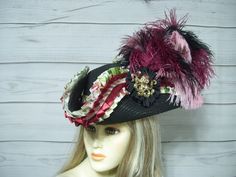 Beautiful one of a kind nice quality black faux straw pirate hat with floral pleated ribbon with burgundy pleats and pink braid, large gold color metal octopus on one side and a metal mermaid on the other, a large floral bow on the back and matching ostrich feathers. Beautiful hat! Please measure your head, this hat is 22.5" for the inside circumference with a built-in hat sizer. Just cinch and tie. I cannot make the circumference bigger. Check out my other pirate hats and other goodies International buyers are responsible for custom fees as it is not included in the shipping. Please Click on the shipping tab to calculate shipping so there are no surprises over shipping.    ALL SALES ARE FINAL!!! NO EXCHANGES! NO REFUNDS! ASK QUESTIONS AHEAD OF TIME AS ALL SALES ARE FINAL!!!   A lot of my Octopus Halloween, Metal Octopus, Black Pirate