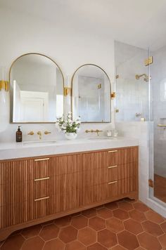 a bathroom with two sinks and three mirrors