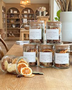 several jars filled with orange slices on top of a wooden table