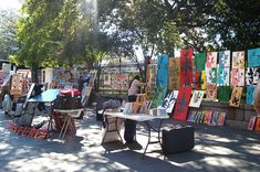 an outdoor art market with paintings on display