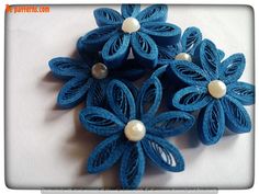 three blue flowers with pearls on them