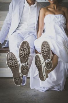 a man and woman sitting on a bench with their feet up in the air next to each other