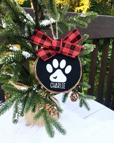 a christmas ornament with a dog's paw on it and a red bow