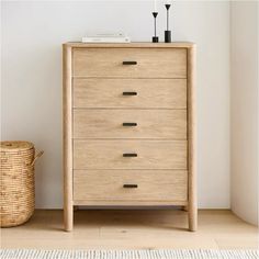 a wooden chest of drawers next to a basket