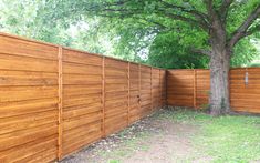 a large wooden fence next to a tree