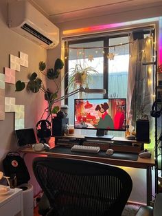 a desk with a computer on it in front of a window and some potted plants