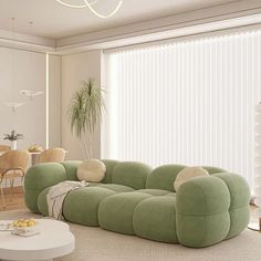 a living room filled with furniture next to a window covered in blinds and drapes