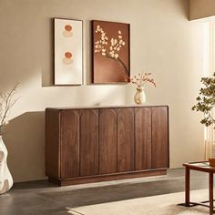 a living room scene with focus on the sideboard and vases in the foreground