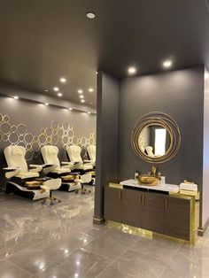 a room with chairs and a mirror in the corner, along with lights on the ceiling