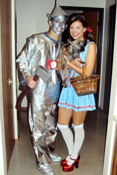 a man and woman dressed up as tinkerbells, one holding a dog