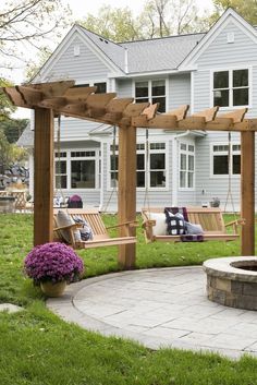 a backyard with a fire pit and wooden swings