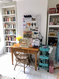 a sewing machine sitting on top of a wooden table in front of a bookshelf