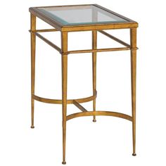 a glass and metal side table with gold trimmings on the bottom, against a white background