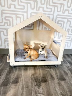 two dogs sitting in their dog bed on the floor