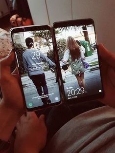 two people holding up their cell phones with the same image on them as they look at each other