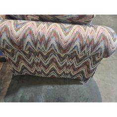 an upholstered couch with multicolored chevron pattern on the back and sides