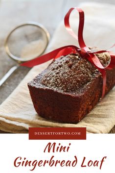 a close up of a loaf of bread on a napkin with a red ribbon around it