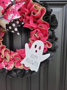 a pink and black wreath with a ghost on it