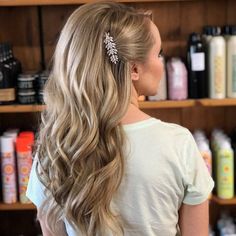 a woman with long hair standing in front of shelves