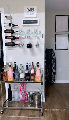 a bar cart filled with lots of bottles and glasses on top of a hard wood floor