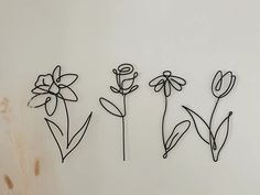 three metal flowers on a white wall