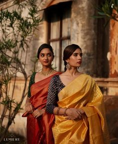 two women standing next to each other in sari