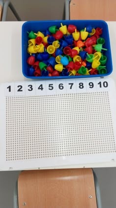 a blue tray filled with lots of different colored plastic letters on top of a table