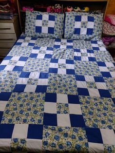 a blue and white checkered bedspread on a bed with drawers in the background