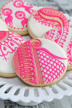 pink and white decorated cookies on a plate