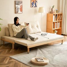 a woman sitting on a couch with her legs crossed and holding a remote control in her hand