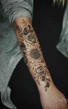 a woman with a sunflower tattoo on her arm and wrist is sitting in a chair