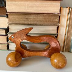 a wooden toy rabbit sitting next to some books