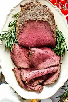 sliced roast beef on a plate with herbs