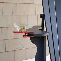 a martini glass sitting on top of a table next to a blue chair with a red handle