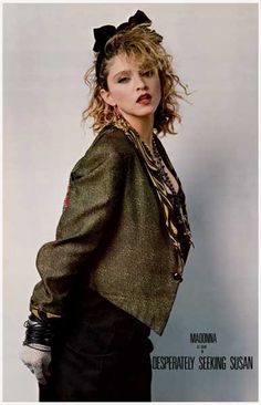 a woman with curly hair wearing a green jacket and black pants, posing for a magazine cover