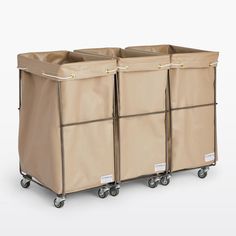 three beige storage bins on wheels with handles