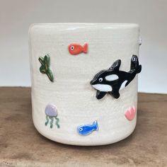 an orca whale and other sea creatures on a white ceramic cup