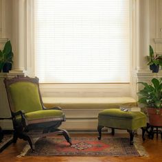 a green chair and ottoman in front of a window