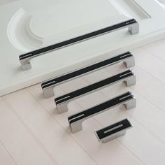 four metal handles on a white counter top