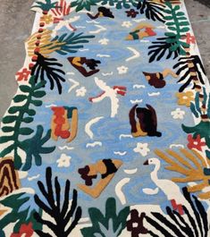 an area rug with birds and plants on it in the middle of a floor mat