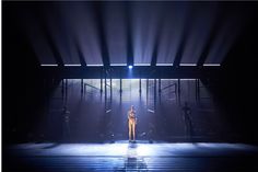 a person standing in front of a stage with lights on the floor and behind them